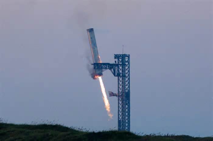 In engineering feat by SpaceX, mechanical arms catch Starship booster back at its launch pad