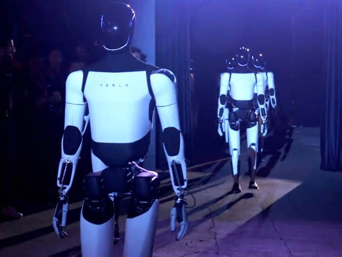 Optimus robots danced on a lit-up stage and served drinks at Tesla's robotaxi event